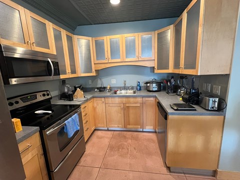 A kitchen with wooden cabinets and a black stove top.