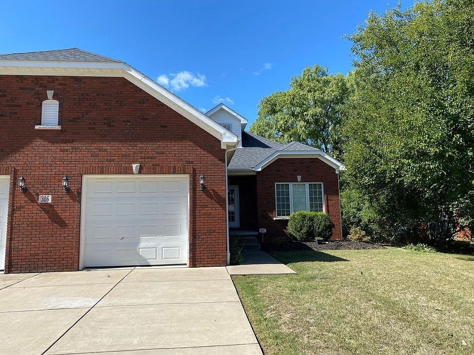 A red brick house with a white garage door.