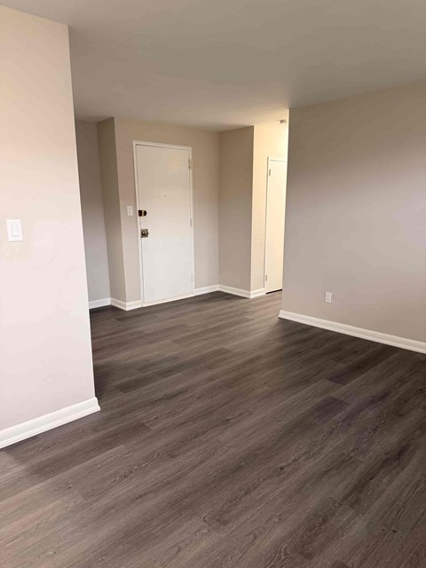 A room with a white door and a grey floor.