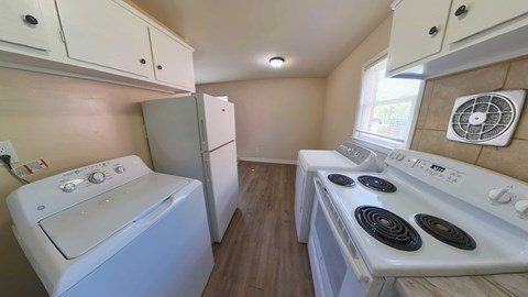 A small kitchen with a white oven and a white washing machine.