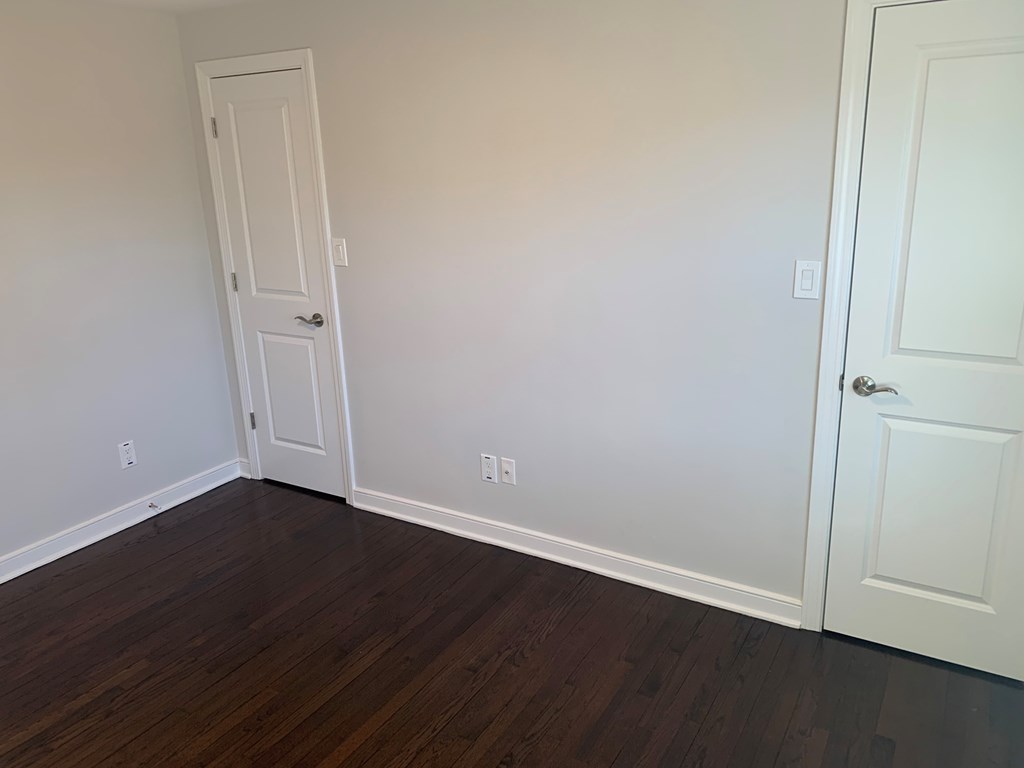 A room with a white door and a white wall.