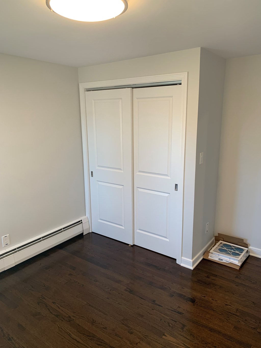 A white door is in a room with wood flooring.