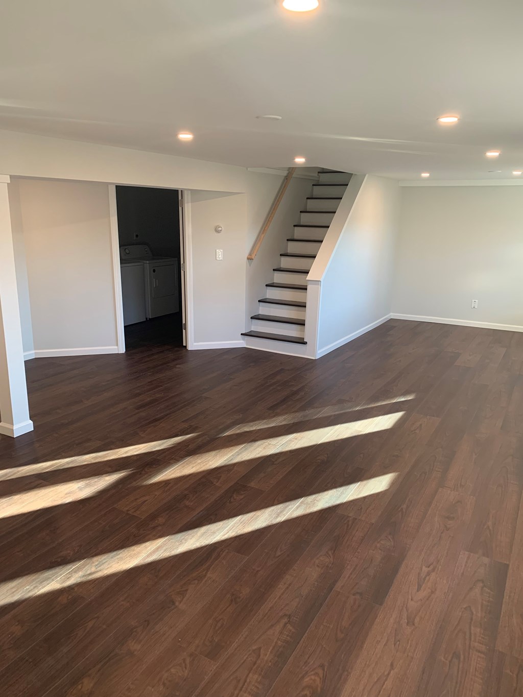 A room with wooden floors and a staircase.