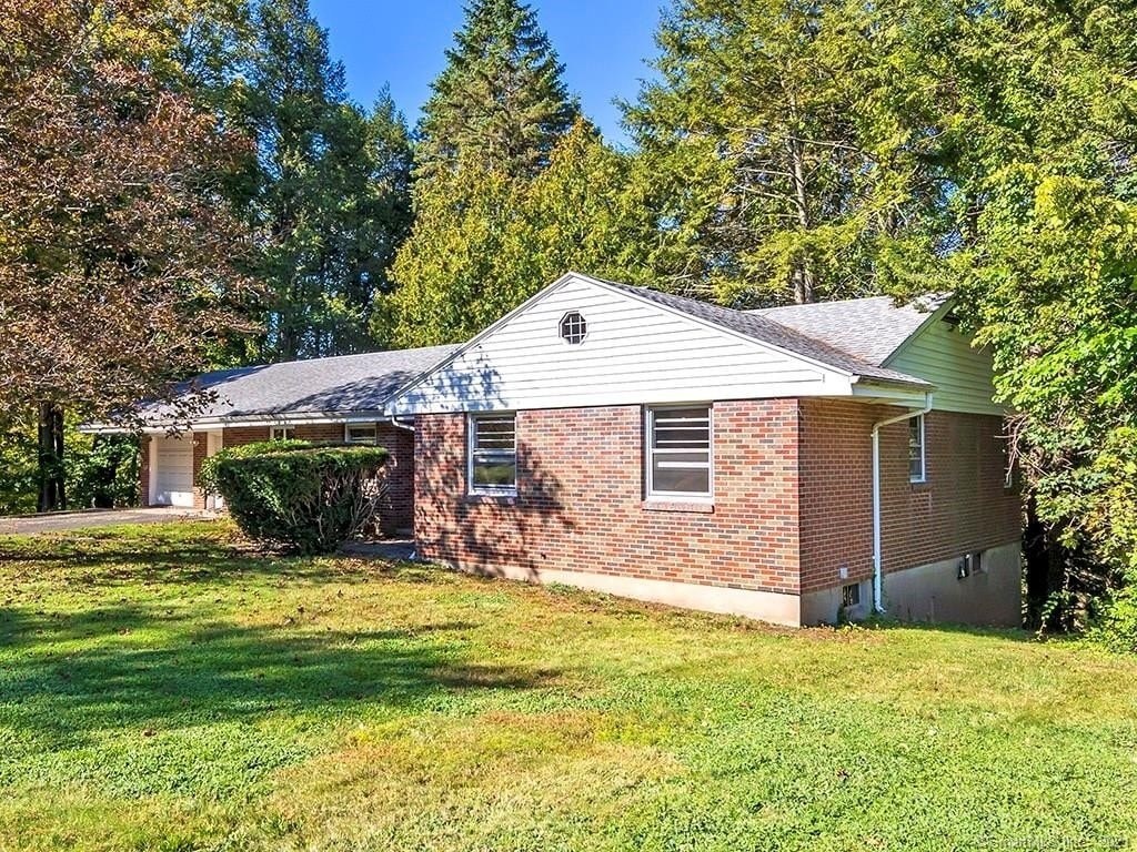 A house with a grey roof and a green lawn in front.