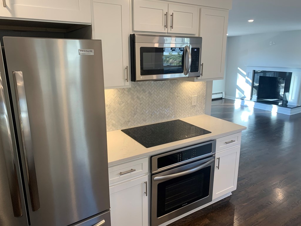 A modern kitchen with a stainless steel refrigerator and microwave.