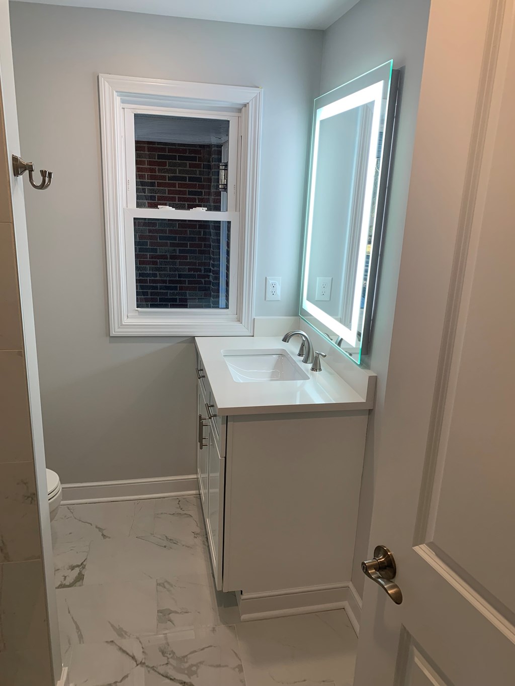 A bathroom with a white sink and a window.