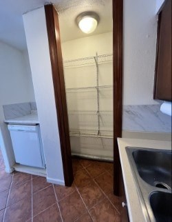 A small kitchen with a sink and a refrigerator.