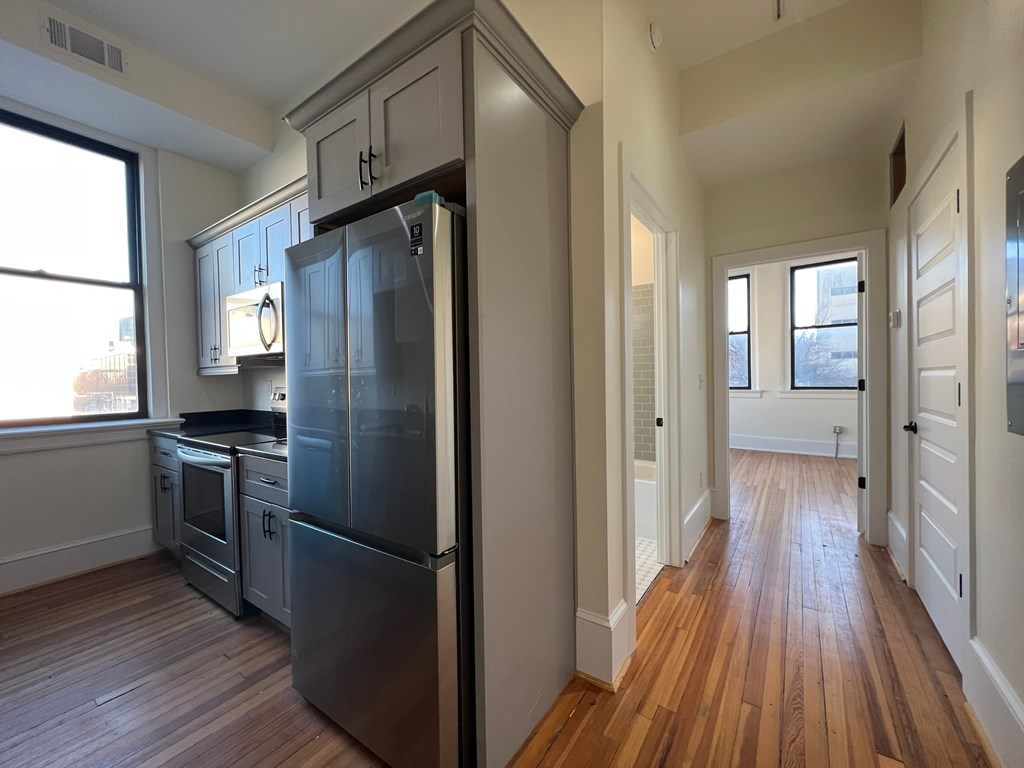 A kitchen with a refrigerator, oven, and sink.