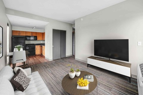 A modern living room with a grey sofa and a wooden coffee table.