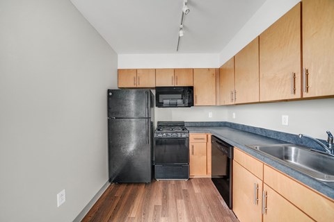 A kitchen with wooden cabinets and black appliances.