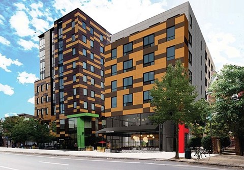 A modern multi-story building with a combination of brown and orange hues.