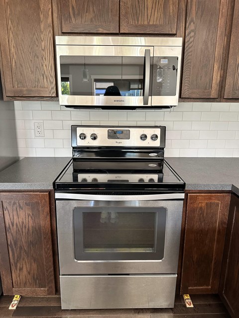A stainless steel oven sits on a countertop in a kitchen.