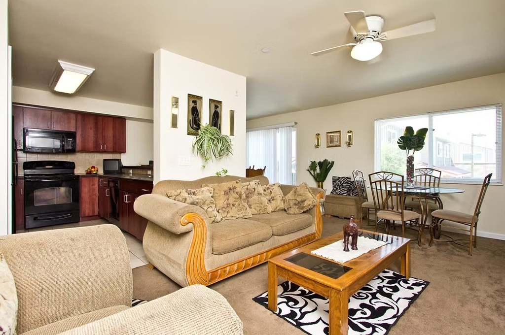 A living room with a couch, chairs, and a coffee table.