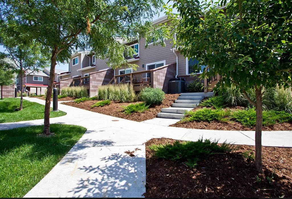 A tree-lined walkway leads to a building.