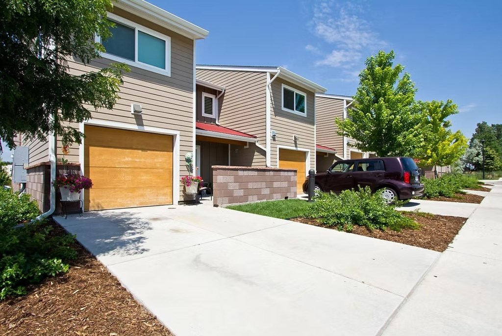 A house with a brown garage door and a black car parked in front.