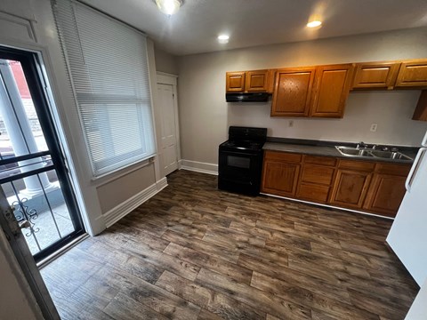 A kitchen with wooden cabinets and a black stove top oven.