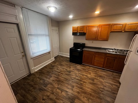A kitchen with wooden cabinets and a black oven.