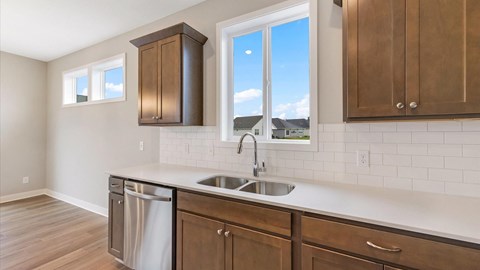 A kitchen with a stainless steel dishwasher and a white countertop.