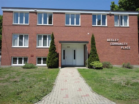 A brick building with a sign that says Wesley Community Place.