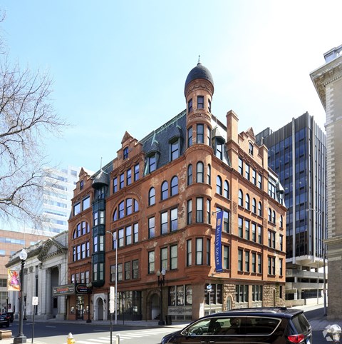 A large red brick building with a black dome on top.
