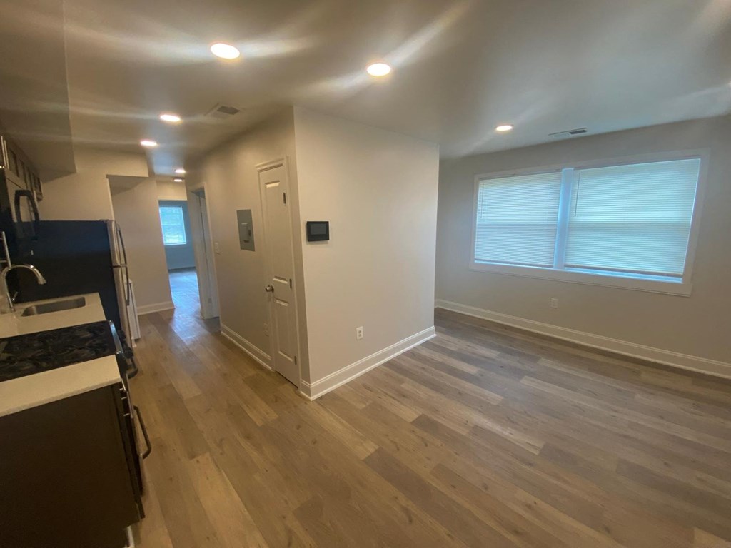 A kitchen with a refrigerator, cabinets, and a countertop.