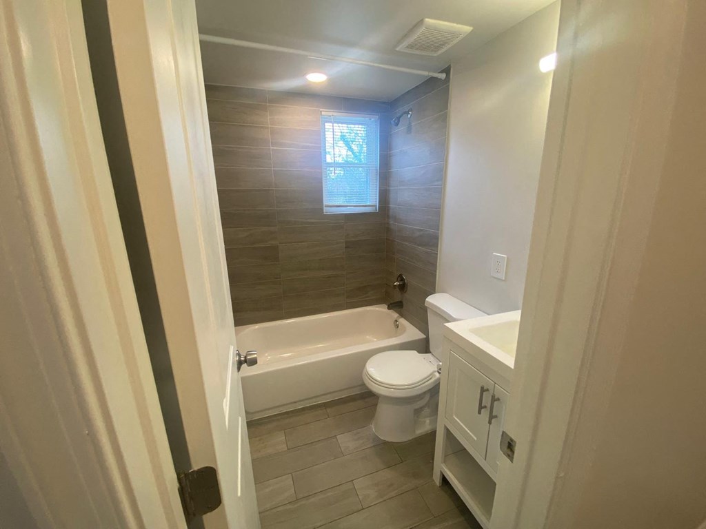 A bathroom with a toilet, sink, and bathtub.
