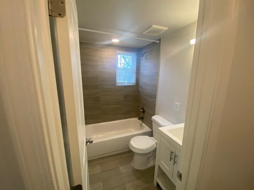 A bathroom with a toilet, sink, and bathtub.