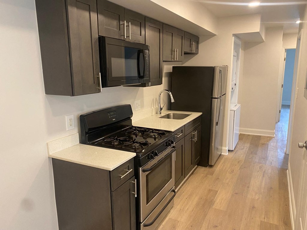 A kitchen with black cabinets and stainless steel appliances.