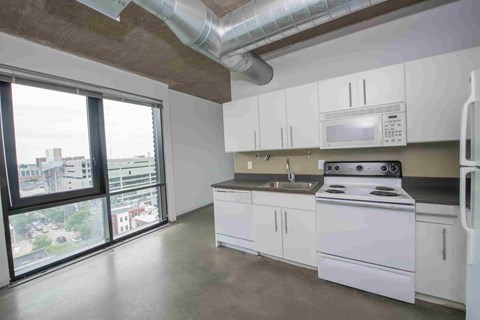 A kitchen with white cabinets and a stove top oven.