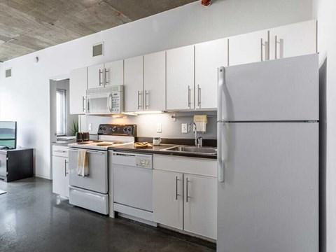 A modern kitchen with white appliances and cabinets.