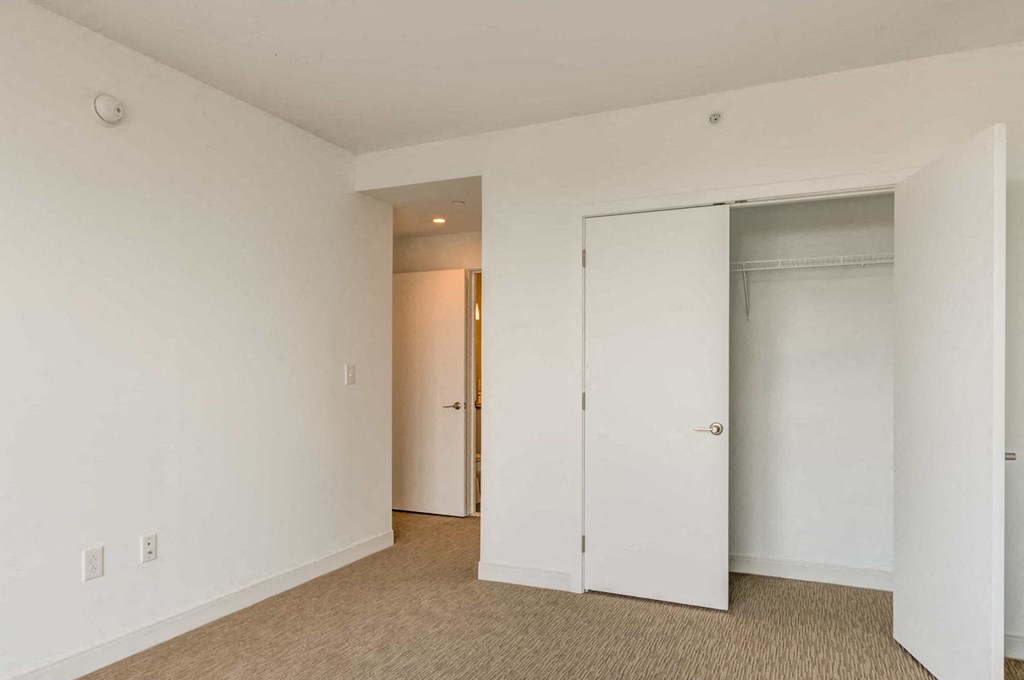 A room with a white wall and a brown carpet.
