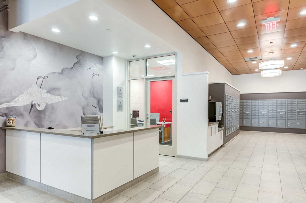 A reception area with a white counter and a red door.