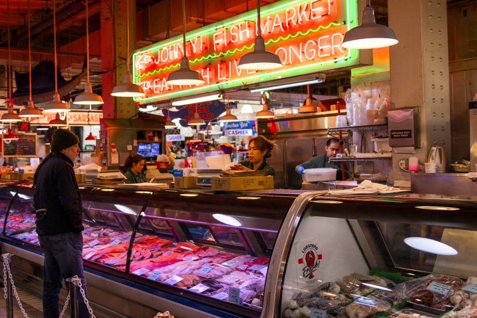 A butcher shop with a neon sign that says "Johnny's Fish Market".