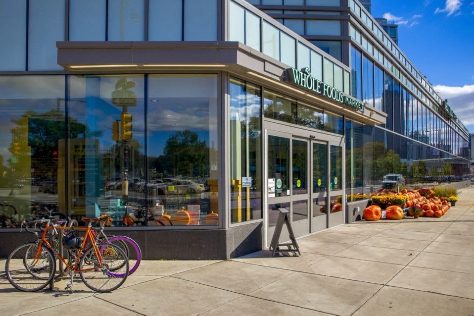 A Whole Foods store with a bicycle parked in front.