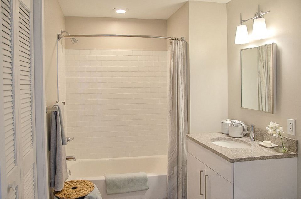 A bathroom with a white tub, sink, and towel.