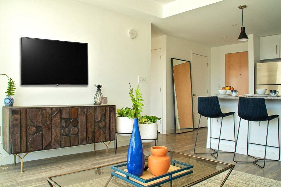A living room with a flat screen TV mounted on the wall.