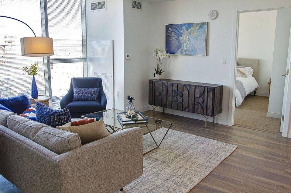 A living room with a brown couch and a blue chair.