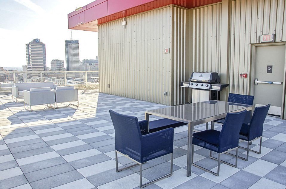 A table with four chairs is on a checkered floor.