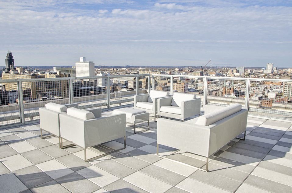 A set of white outdoor furniture is on a tiled roof.