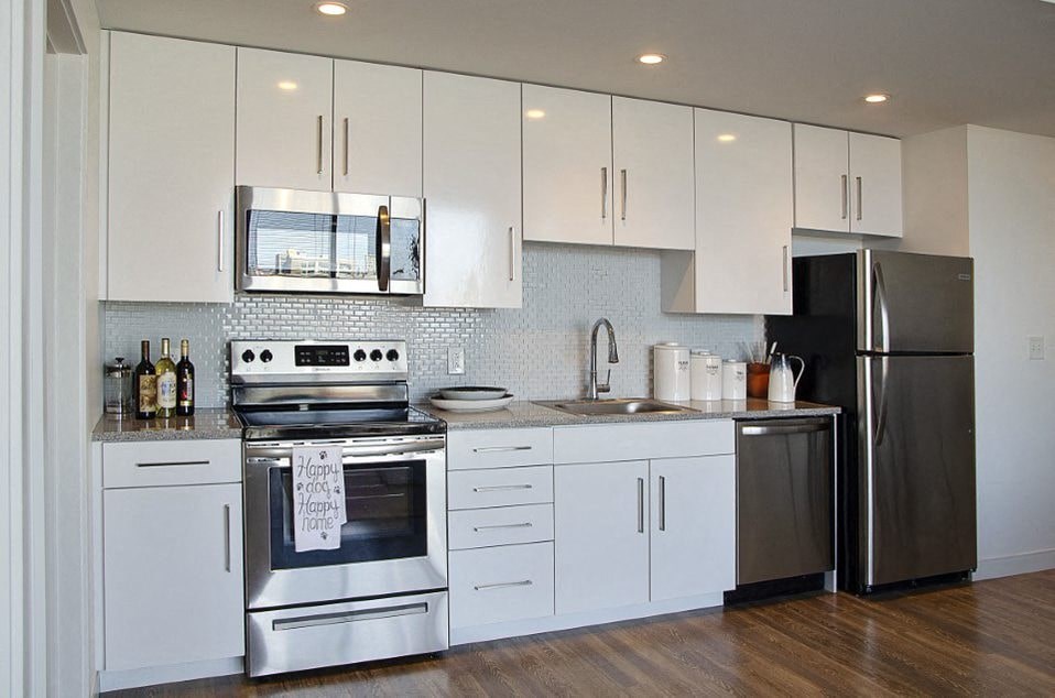 A kitchen with white cabinets and stainless steel appliances.