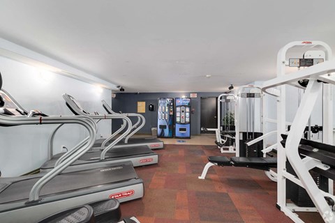 A gym with treadmills, elliptical machines, and other exercise equipment.