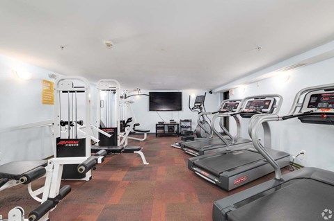 A gym with treadmills, weights, and exercise equipment.
