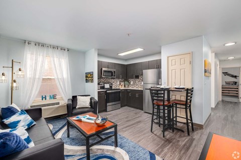 A modern living room with a black leather couch and a wooden coffee table.