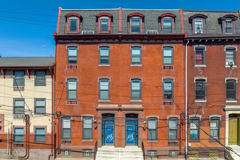 A red brick building with a blue door in front.