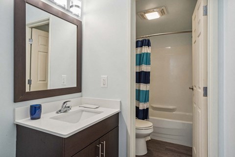 A bathroom with a white sink and a blue and white striped shower curtain.