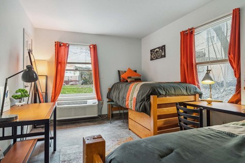 A bedroom with a bed, desk, and chair.