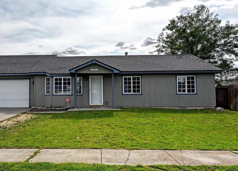A grey house with a white door and windows.