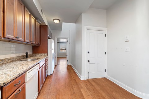 A kitchen with wooden cabinets and a marble countertop.