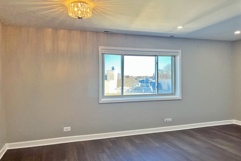 A room with a large window and a wooden floor.