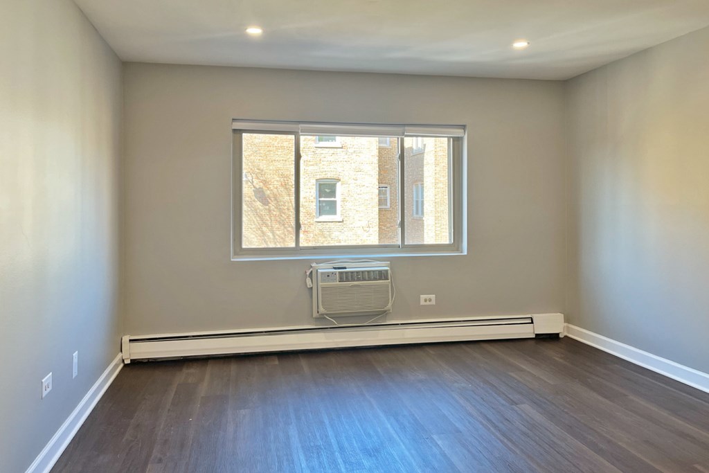 A room with a window and a radiator on the floor.